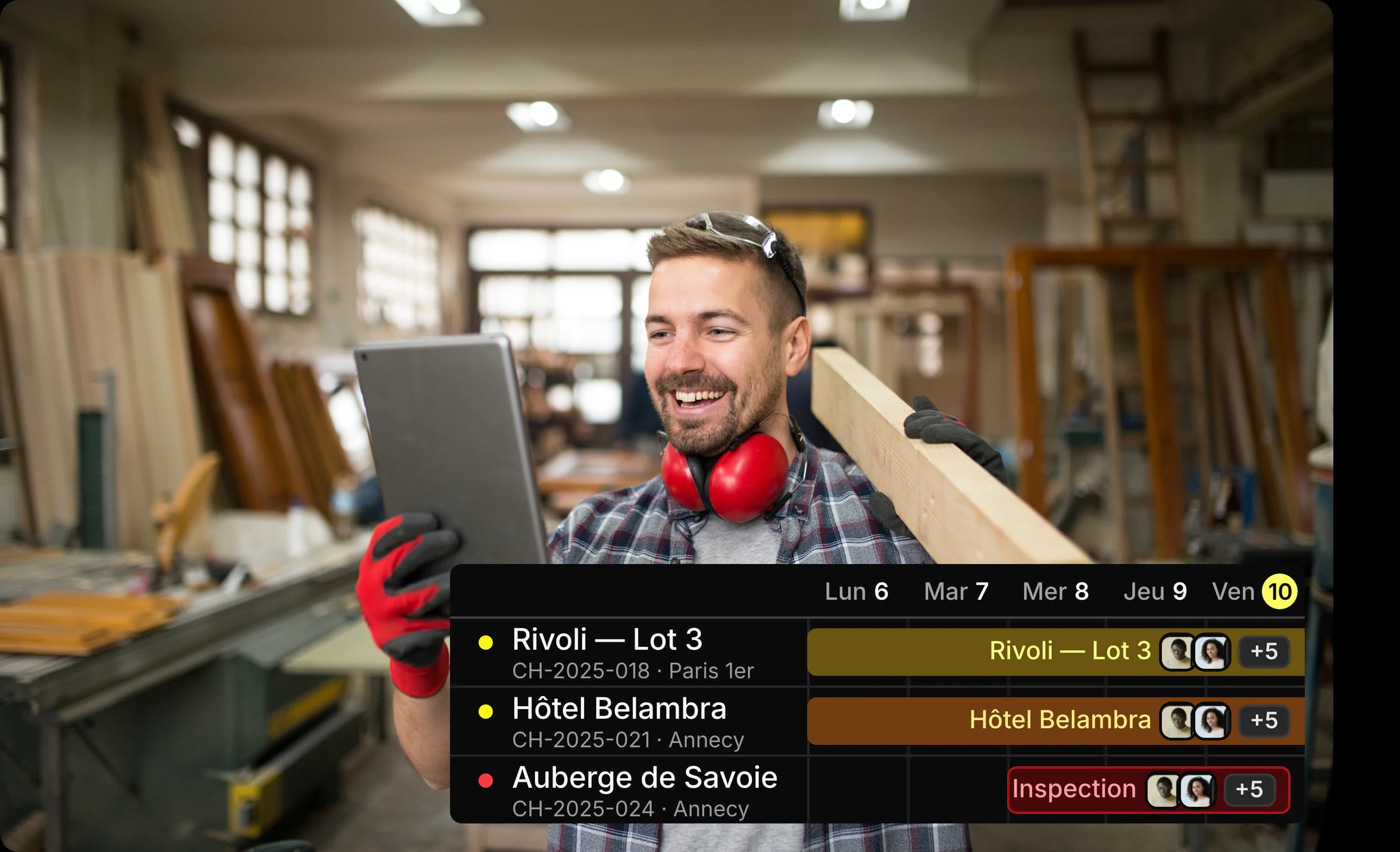 Un menuisier consultant sur sa tablette le planning des chantiers, dans son atelier.